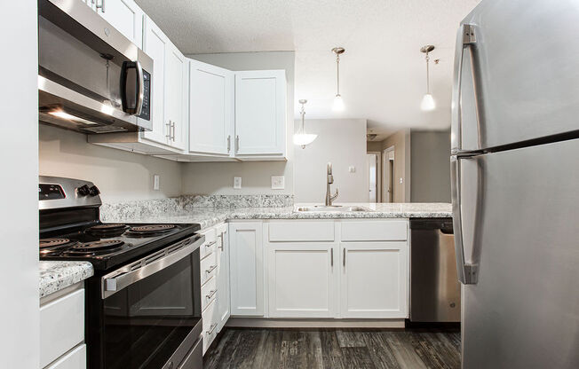 a kitchen with white cabinets and stainless steel appliances