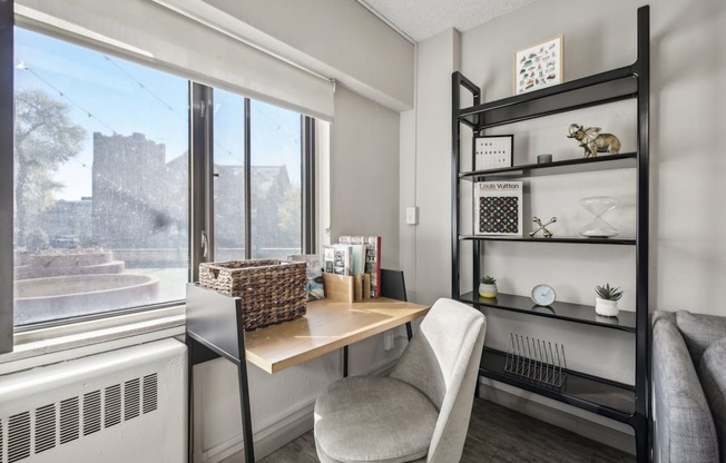 a home office with a large window and a desk with a chair