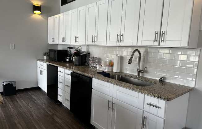 a kitchen with white cabinets and a granite counter top