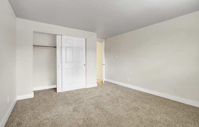 an empty room with carpet and a closet at 2000 Lake Washington Apartments, Washington, 98056