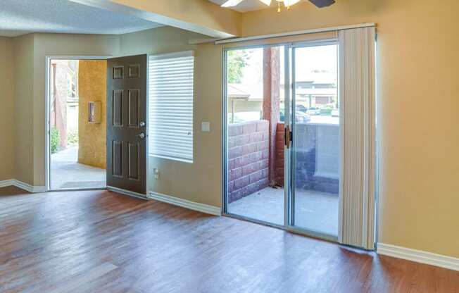 an empty living room with sliding glass doors to a patio