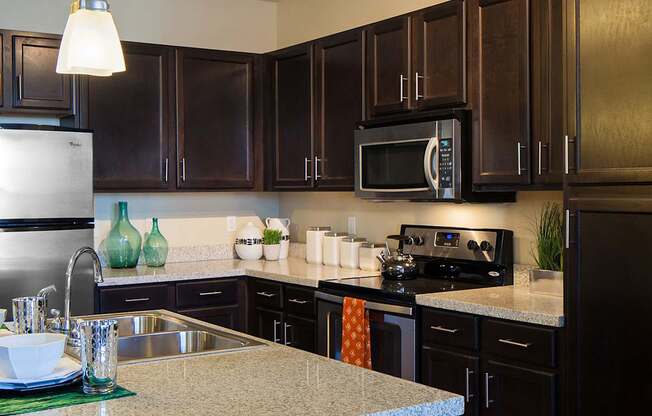 a kitchen with dark cabinets and white countertops