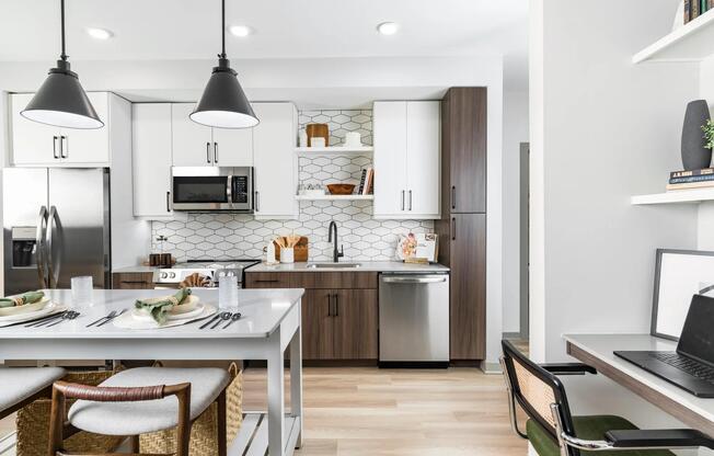 Modern kitchen with two-tone cabinets and workspace nearby—ideal for everything from meal prep to meetings.