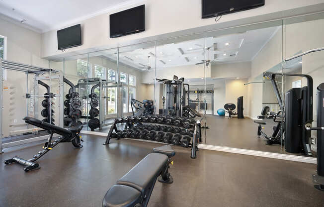 A gym with a variety of equipment including weights and cardio machines.