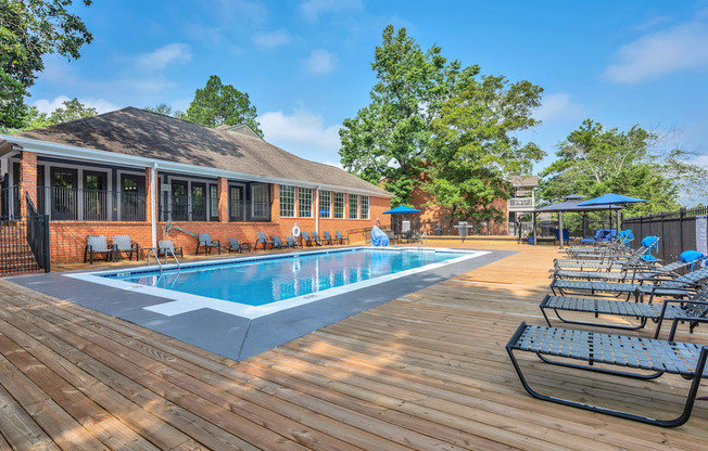 a swimming pool with chairs around it outside of a building