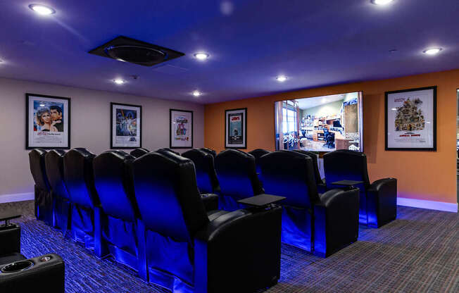 a theater room with blue chairs and a projector screen