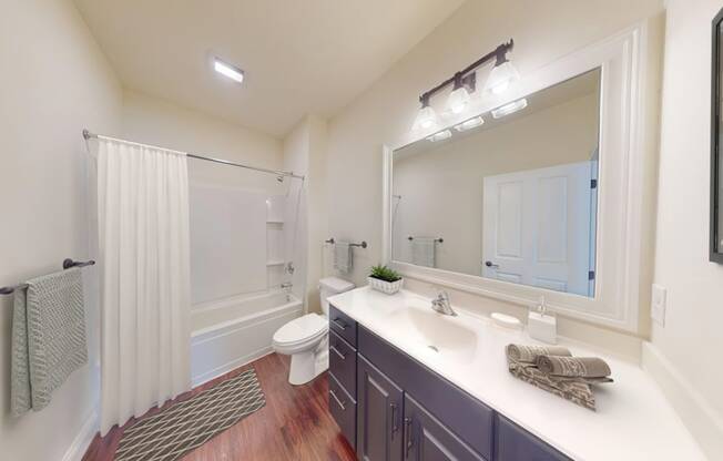 A bathroom with a toilet, sink, and mirror.