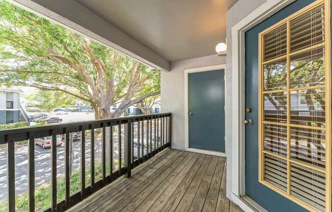 A balcony with a black railing and a blue door.