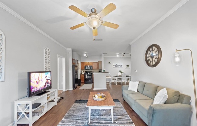 a living room with a couch and a coffee table in front of a tv