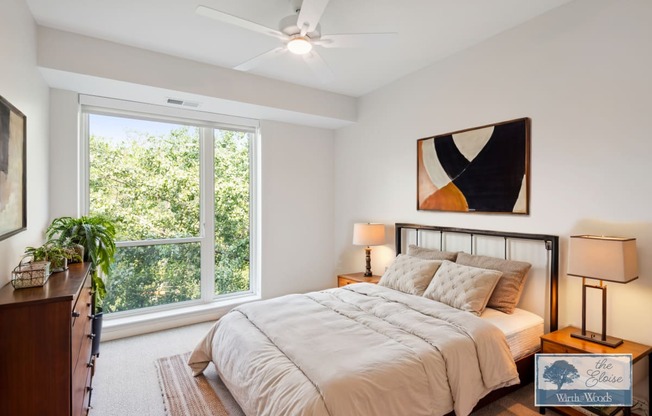 a bedroom with a bed and a ceiling fan