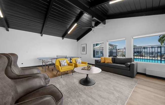 A living room with a grey couch, yellow armchair, and a grey rug.