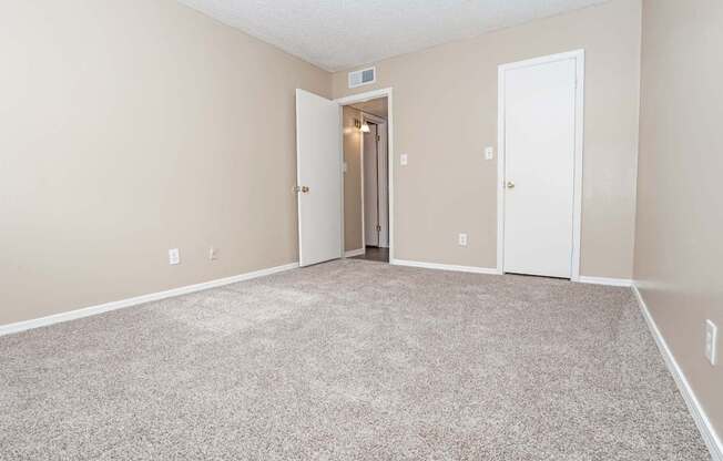 A bedroom with carpeted floor and a closet  at The Creole Apartments in Shreveport, LA
