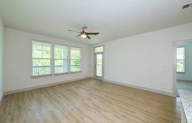 an empty living room with a ceiling fan and windows at Legacy at Cibolo, Boerne