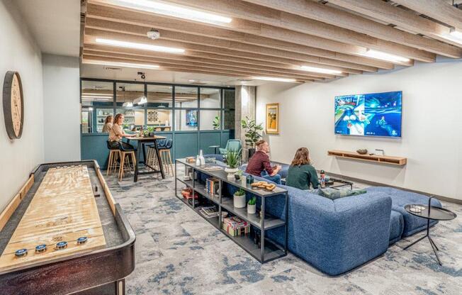 people sitting on a couch in a room with a pool table