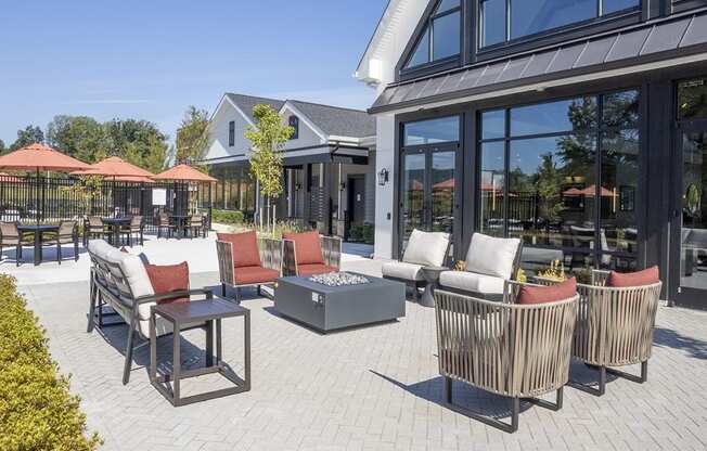 a patio with chairs and tables outside of a building