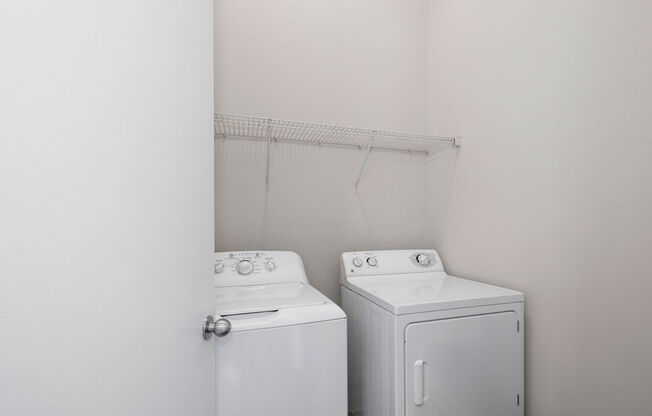 an empty laundry room with two washes and a dryer