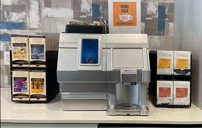 A coffee machine with a sign that says "Bring your mug" is on a counter.