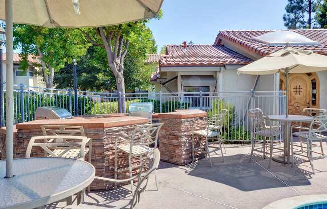 A patio with a table, chairs, and an umbrella.