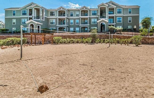 an empty volleyball court in front of an apartment building