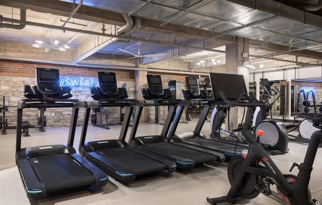 a group of treadmills and other exercise equipment in a gym