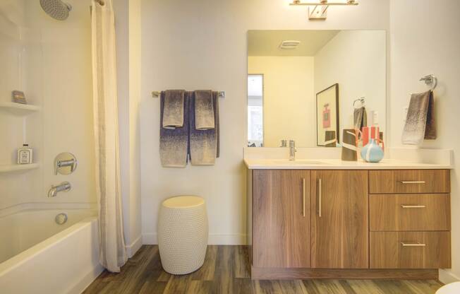 a bathroom with wooden cabinets and a white bathtub