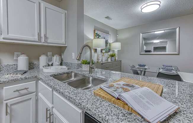 A kitchen with granite countertops and white cabinets.