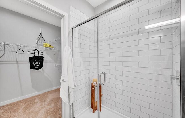 a white bathroom with a shower with a glass door