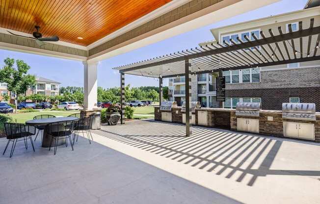 A patio with a table and chairs under a roof.