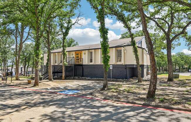 A building with a yellow door is surrounded by trees.