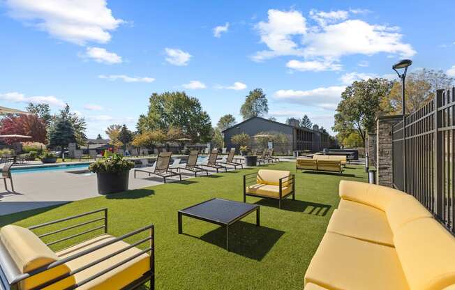 a patio with a couch and chairs and a pool