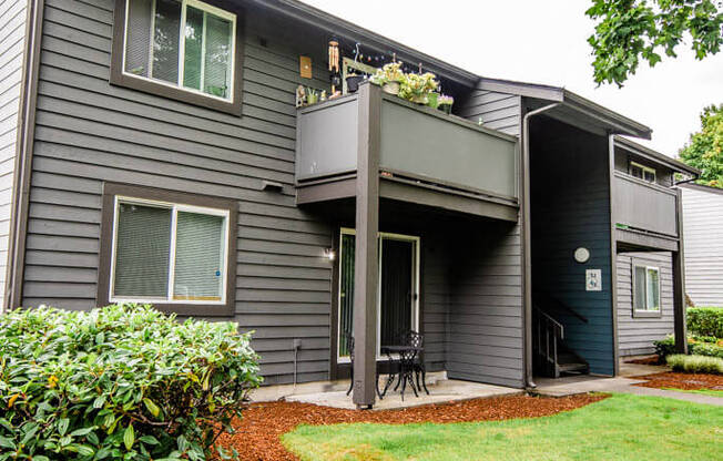 A grey house with a green lawn in front.