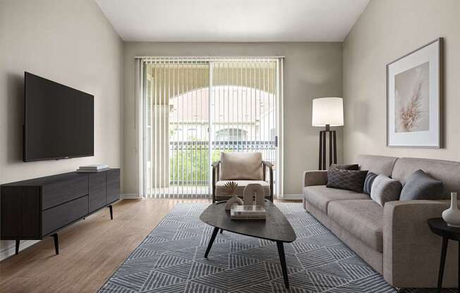 A living room with a grey couch, a black cabinet, a black coffee table, a flat screen TV, a floor lamp, and a framed picture on the wall.