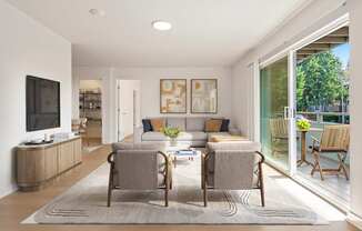 A living room with a grey rug and two chairs.