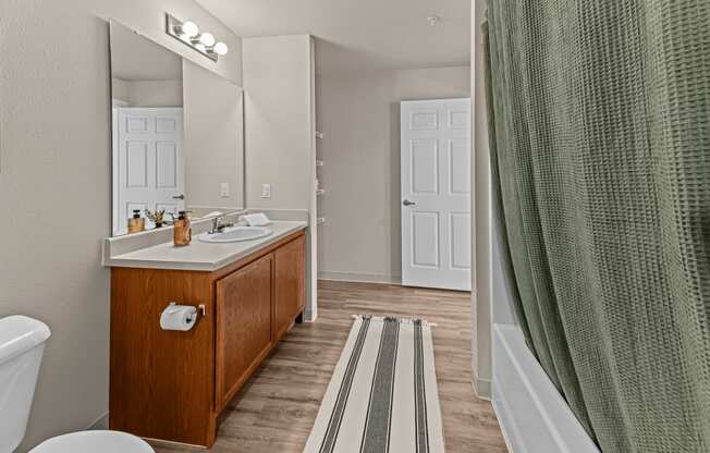 a bathroom with a shower and a sink and a mirror