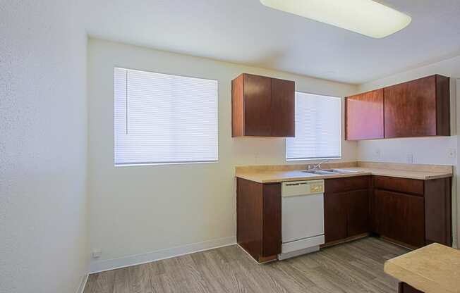 a kitchen with brown cabinets and a white dishwasher