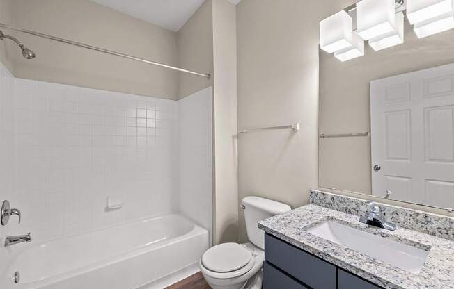 A white bathroom with a toilet, sink, and bathtub.