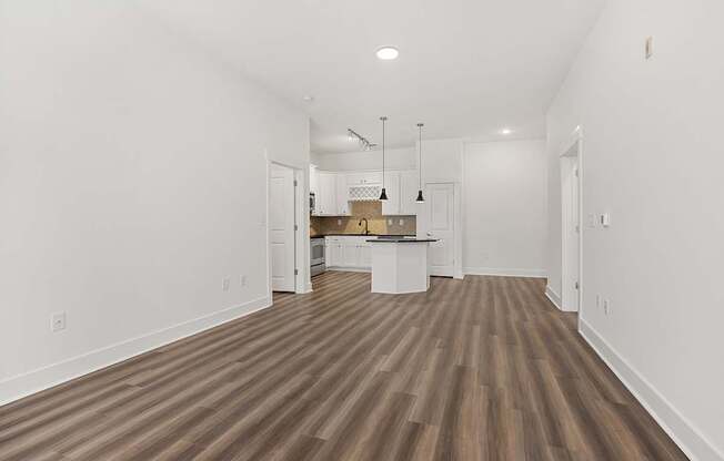 A room with wooden flooring and white walls.