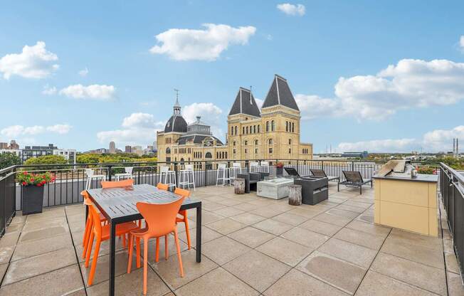 A table and chairs are set up on a rooftop patio.