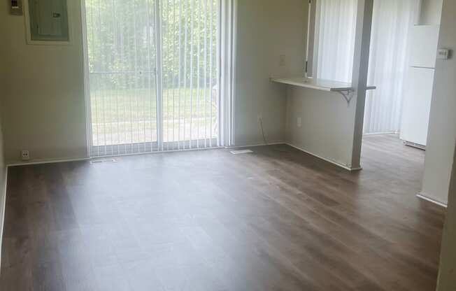 The living room in a 1 bedroom apartment with a sliding glass door.