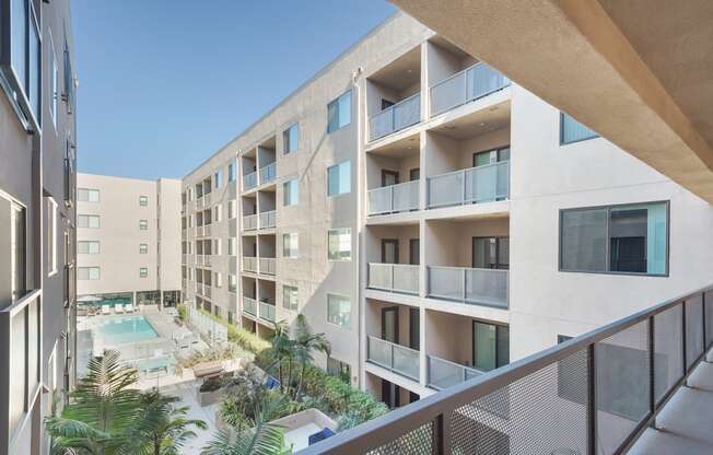A modern apartment complex with a pool and balconies.