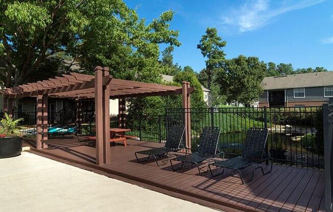 A wooden deck with a pergola and chairs. at Bradford Pointe, Augusta, Georgia