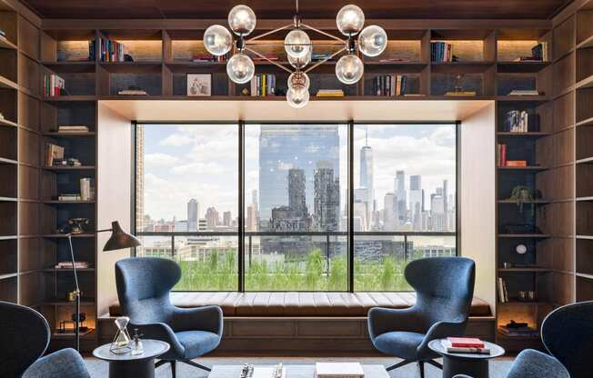 a living room with chairs and a table and a window at The Lively, Jersey City, 07302