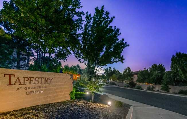 a sign for tapestry at night