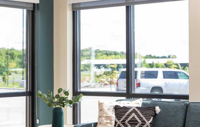 a living room with a couch and a table and windows