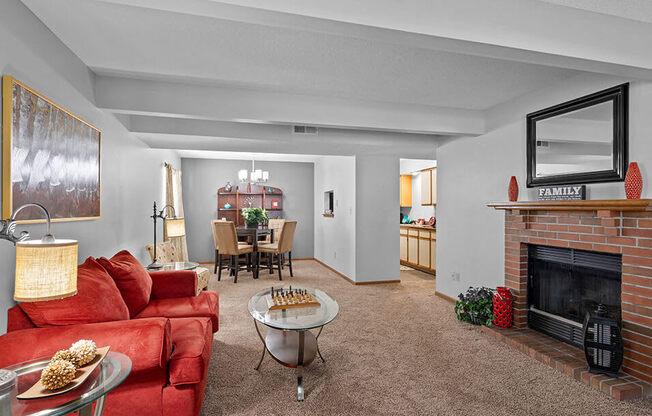 a living room with a red couch and a fireplace