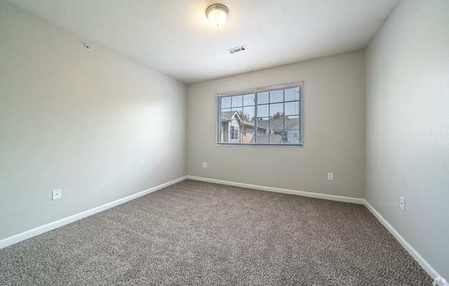 an empty room with carpet and a window