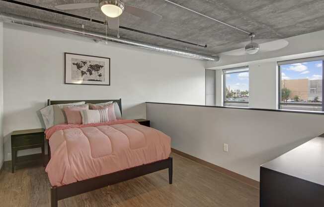 a bedroom with a bed and two windows