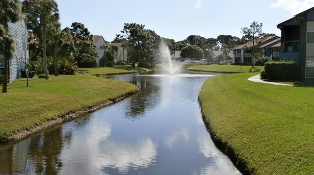 A resort-style community with lush landscaping and lake views at Lake in the Woods, Melbourne, FL