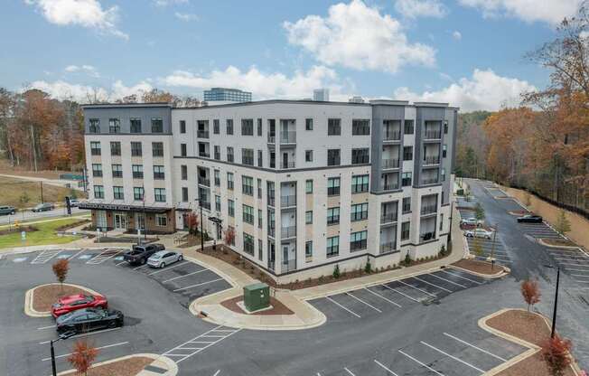 A large white building with a parking lot in front.