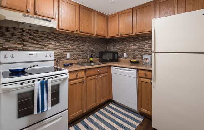 a kitchen with white appliances and wood cabinets